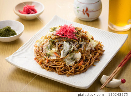 新鮮出爐的熱騰騰的炒麵配上醬汁和冰鎮啤酒——這是經典的居酒屋菜單，配有飲料。 130243375