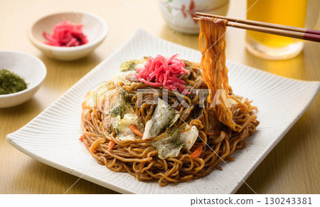 新鮮出爐的熱騰騰的炒麵配上醬汁和冰鎮啤酒——這是經典的居酒屋菜單，配有飲料。 130243381