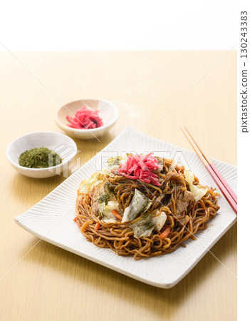 Freshly made piping hot yakisoba noodles with sauce, a classic home-cooked noodle dish garnished with pickled ginger and green laver. Freshly made piping hot yakisoba noodles with sauce, a classic home-cooked noodle dish garnished with pickled ginger and green laver. 130243383