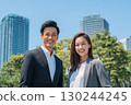 young japanese business people, a man and a woman, in office attire are smiling and looking at the camera 130244245