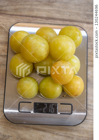 portion control: fresh mirabelle plums on a kitchen scale 130244696