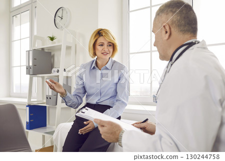 Female mature patient visiting a doctor at the medical office during medical examination. Female mature patient visiting a doctor at the medical office during medical examination. 130244758