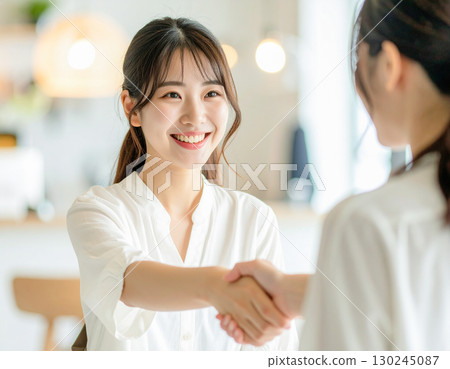 Smiling woman shaking hands 130245087