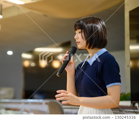 Female student speaking into a microphone (side profile) 130245316