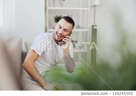 A man enjoying an emotional phone call, reflecting a blend of vulnerability and authentic connection. The image evokes modern feelings of mental health and therapy culture. A man enjoying an emotional phone call, reflecting a blend of vulnerability and authentic connection. The image evokes modern feelings of mental health and therapy culture. 130245503