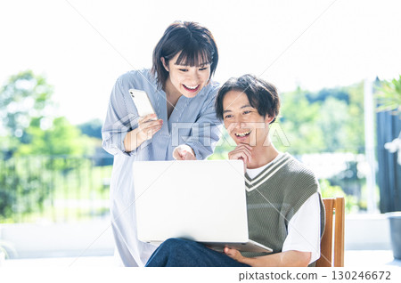A couple searching on a computer and smartphone 130246672
