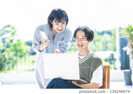 一對夫婦正在用電腦和智慧型手機搜索 130246674