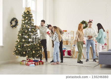 Friends Decorating Christmas Tree During New Year Or Christmas Party At Home 130246860