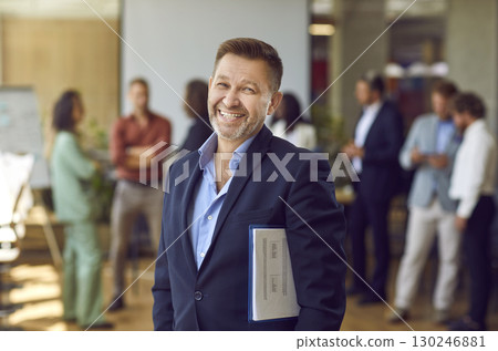 Mature happy joyful business man looking at the camera and smiling in the office. Mature happy joyful business man looking at the camera and smiling in the office. 130246881