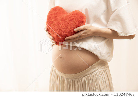 八個月的孕婦拿著一顆紅心 八個月的孕婦拿著一顆紅心 130247462