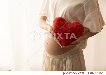 八個月的孕婦拿著一顆紅心 八個月的孕婦拿著一顆紅心 130247464