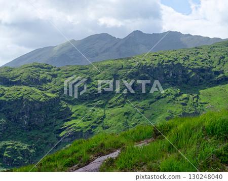 Scenic view of mountains and lush vegetation in Gap of Dunloe, County Kerry, Ireland. Scenic view of mountains and lush vegetation in Gap of Dunloe, County Kerry, Ireland. 130248040