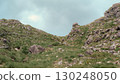 This captures a view looking up through the Gap of Dunloe. The rocky terrain is covered with green grass, creating a rugged landscape. It is located in County Kerry, Ireland. 130248050