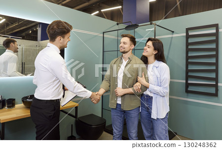 Happy Married Couple Shaking Hands with Consultant in Hardware Store Happy Married Couple Shaking Hands with Consultant in Hardware Store 130248362