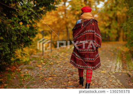 Seen from behind woman in red hat walking Seen from behind woman in red hat walking 130250378