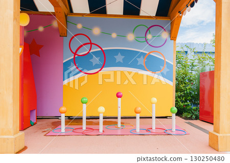 Colorful ring toss setup in a playful outdoor setting features vibrant poles and a cheerful backdrop. Perfect for family fun, carnival events, or enhancing play areas. Colorful ring toss setup in a playful outdoor setting features vibrant poles and a cheerful backdrop. Perfect for family fun, carnival events, or enhancing play areas. 130250480