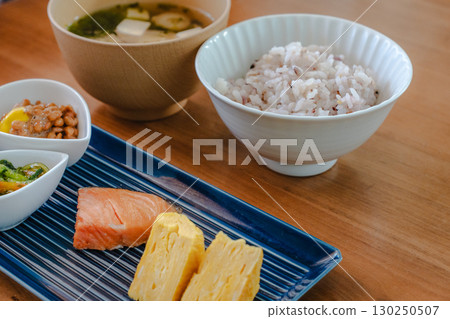 日式早餐，包括烤鮭魚和煎蛋捲、納豆、味噌湯和混合穀物米飯 130250507