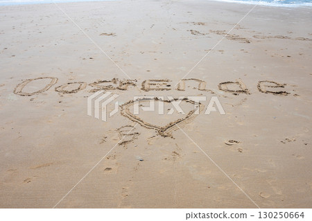 Ostend love exclamation word on sea sand background. Belgium. Ocean beach for walking way. Ostend love exclamation word on sea sand background. Belgium. Ocean beach for walking way. 130250664