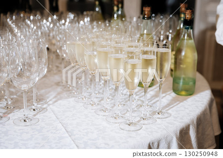 Elegant glasses of champagne arranged on a table at a festive event or celebration Elegant glasses of champagne arranged on a table at a festive event or celebration 130250948