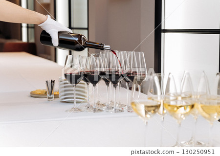Elegant wine pouring at formal event with white glove service Elegant wine pouring at formal event with white glove service 130250951