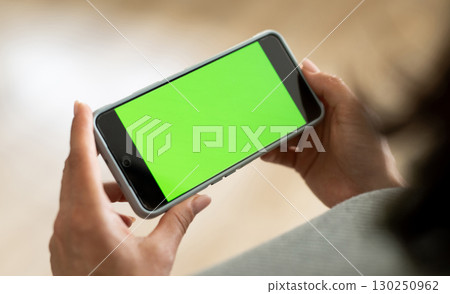 Girl Holding Smartphone With Green Chromakey Screen Blank For Your Text And Design Girl Holding Smartphone With Green Chromakey Screen Blank For Your Text And Design 130250962