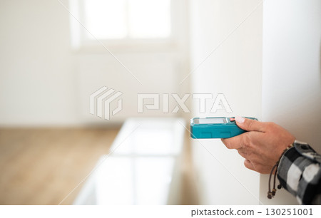 Girl Measuring Room Dimensions With Laser Distance Meter Tool 130251001