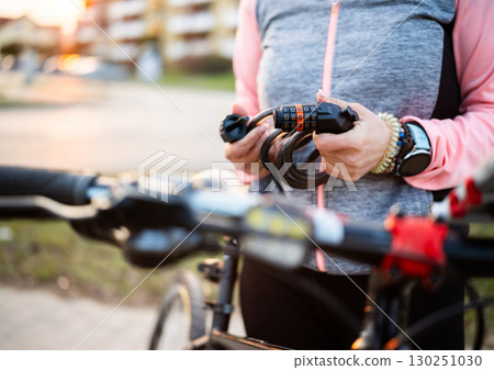 Girl With Code Bike Lock In Hands On A Bicycle Parking Girl With Code Bike Lock In Hands On A Bicycle Parking 130251030