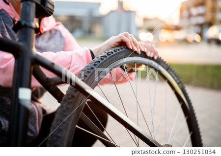 Girl Checking Rear Bike Tire Wheel Pressure 130251034