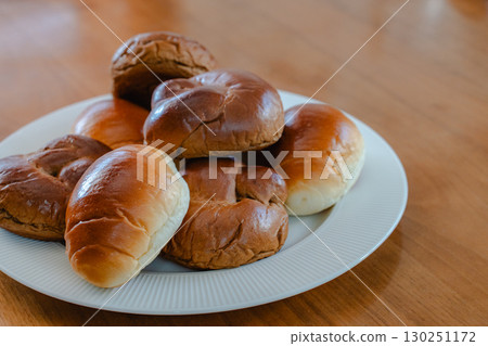 Breakfast of bread rolls served on a white plate Breakfast of bread rolls served on a white plate 130251172