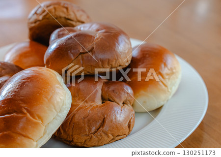 Breakfast of bread rolls served on a white plate Breakfast of bread rolls served on a white plate 130251173