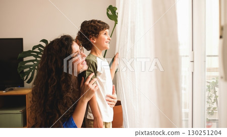 Mother and son sharing a happy moment looking out the window Mother and son sharing a happy moment looking out the window 130251204