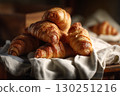 Freshly baked croissants placed on a rustic wooden table 130251216