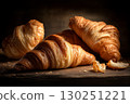 Warm croissants on a rustic table with soft white linen, cozy farmhouse bakery style. 130251221