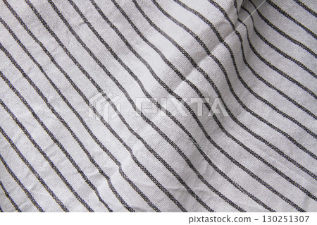 Plaid material. Towel on the table. Wrinkled fabric with stripes. Plaid material. Towel on the table. Wrinkled fabric with stripes. 130251307