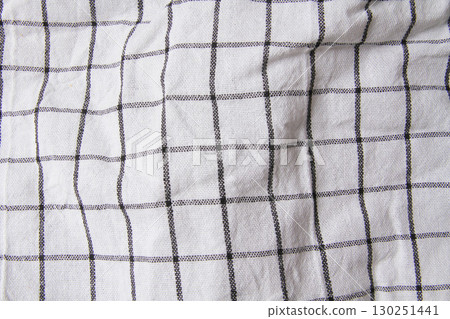 Plaid material. Towel on the table. Wrinkled fabric with stripes. Plaid material. Towel on the table. Wrinkled fabric with stripes. 130251441
