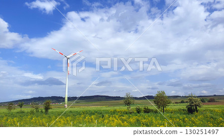 Big white windmill with green field and blue sky. Wind turbine for alternative green energy in Europe. Big white windmill with green field and blue sky. Wind turbine for alternative green energy in Europe. 130251497