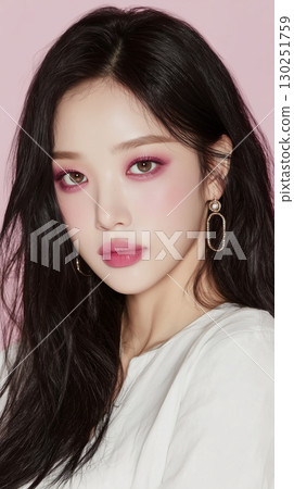 Young woman with vivid makeup and long black hair poses against a pink background, showcasing fashion and beauty trends in Korea Young woman with vivid makeup and long black hair poses against a pink background, showcasing fashion and beauty trends in Korea 130251759