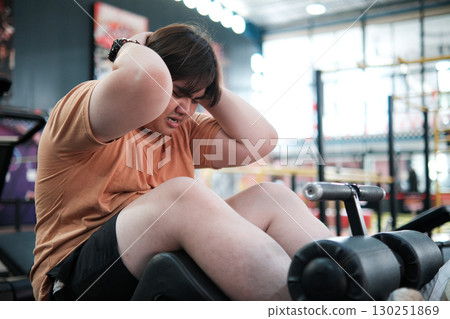 Overweight Man Exercising with Sit Ups at Gym Fitness and Weight Loss Concept. 130251869