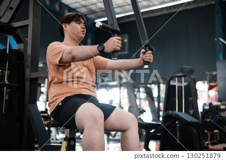 Overweight Man Using Chest Fly Machine at Gym. Strength and Fitness Training Overweight Man Using Chest Fly Machine at Gym. Strength and Fitness Training 130251879