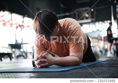 Overweight Man Doing Plank Exercise on Mat at Gym. Core Strength and Endurance Training Overweight Man Doing Plank Exercise on Mat at Gym. Core Strength and Endurance Training 130251888