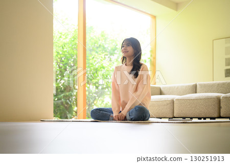A woman relaxing in the living room A woman relaxing in the living room 130251913