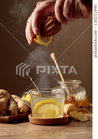 Ginger tea with lemon and honey on a brown ceramic table. Ginger tea with lemon and honey on a brown ceramic table. 130251940