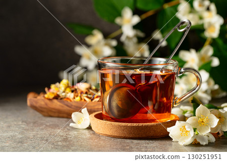 Cup of jasmine tea and fresh jasmine flowers on a stone table. 130251951