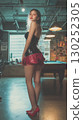 Young Korean woman poses elegantly in a stylish outfit at a trendy urban venue 130252305