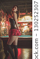 Vibrant Korean performer in striking outfit poses confidently in a stylish bar at night 130252307