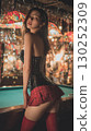 Model poses elegantly in a stylish outfit at an upscale venue with vibrant decor and soft lighting 130252309