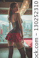 Korean woman poses in a stylish outfit against a city skyline during twilight hours 130252310
