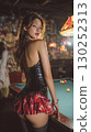 Model poses confidently in a bar setting wearing a stylish outfit with plaid details and a corset during an evening event 130252313