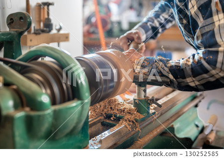 Carpentry. Turnery of a wooden bowl with spiral sawdust shavings with hand and chisel 130252585