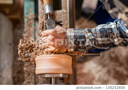 Carpentry. Turnery of a wooden bowl with spiral sawdust shavings with hand and chisel 130252600